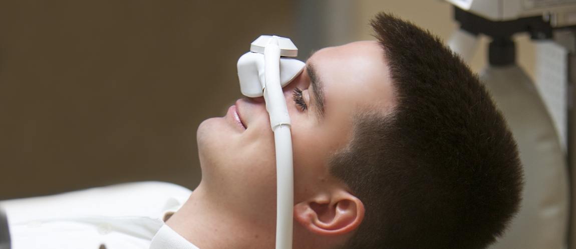 Man in dental chair with nitrous oxide mask on his nose