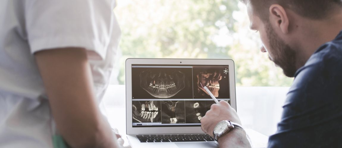 Dentist looking at x rays of teeth