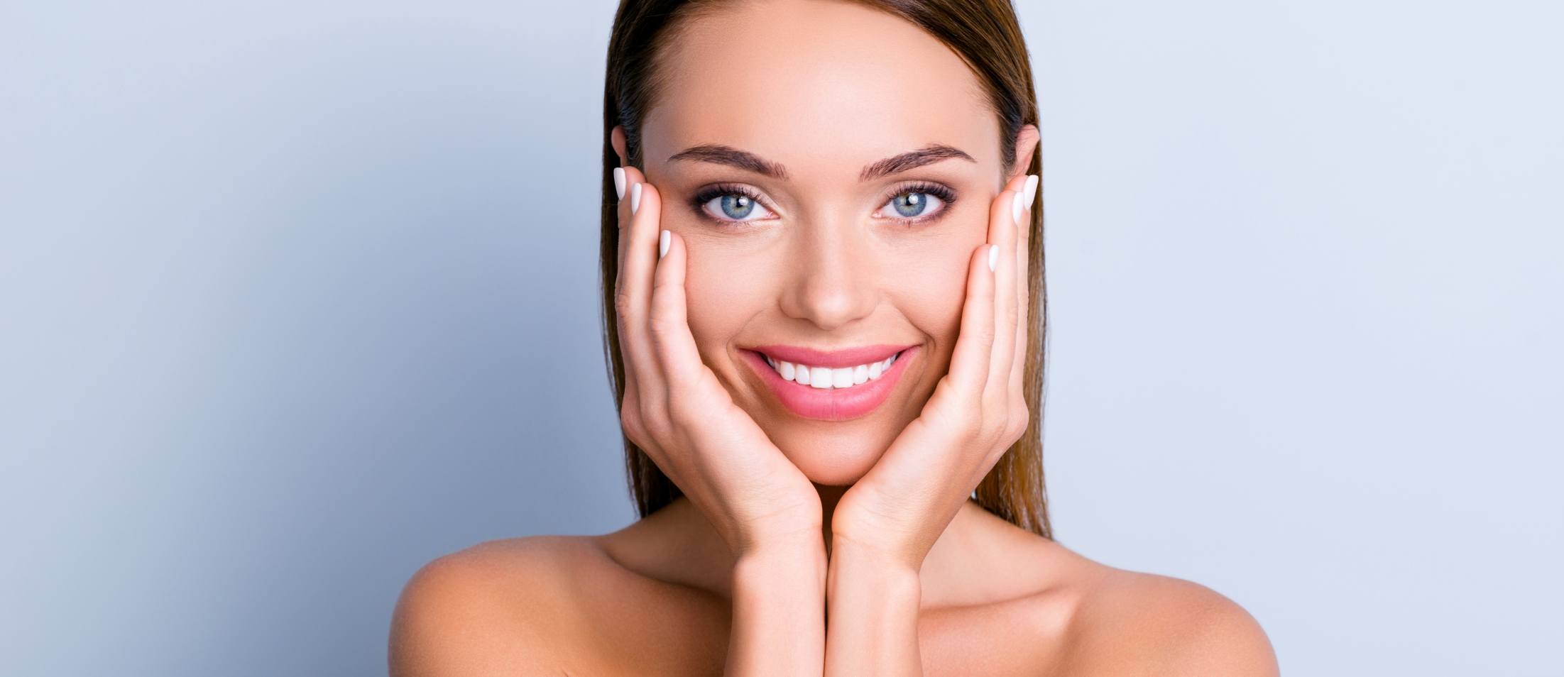 woman smiling and touching her face