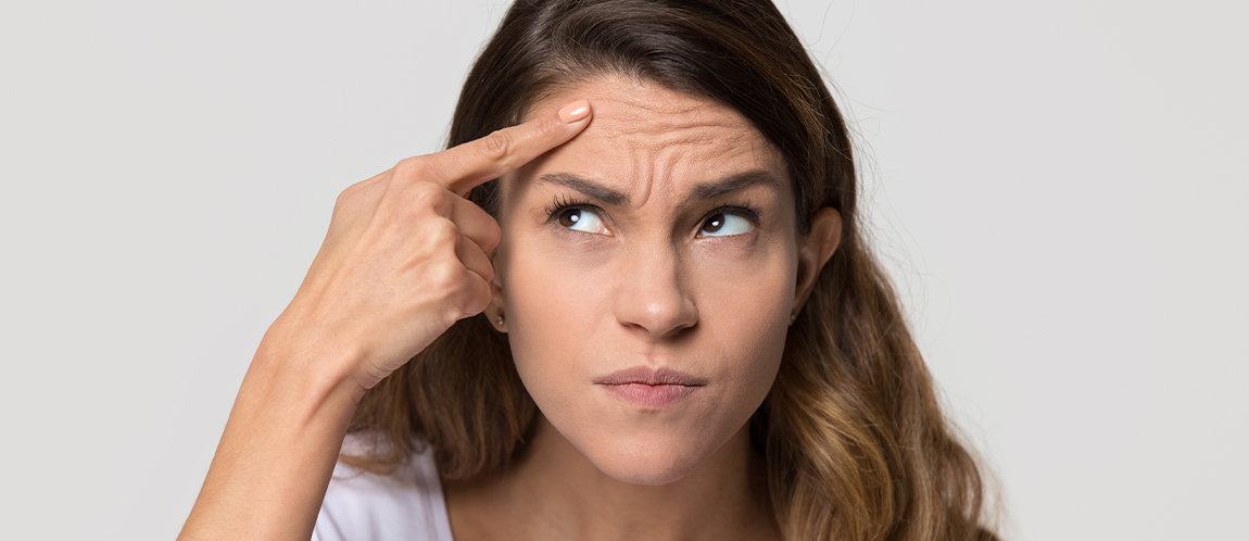 Woman pointing to her forehead