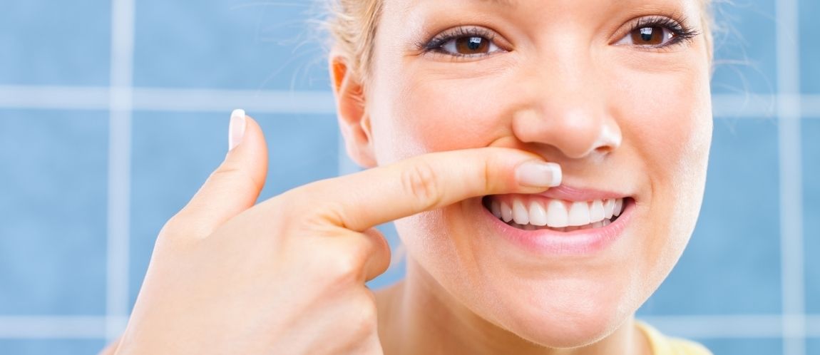 Woman looking at her gums in the mirror