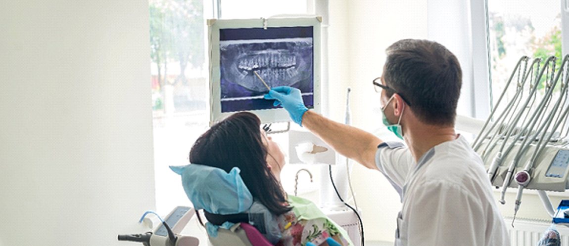 Dentist examining an X ray with a patient