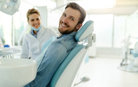 Male patient smiling while relaxing in treatment chair